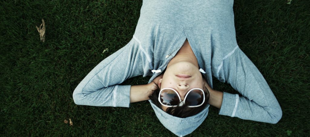 Woman Relaxing on grass wearing sunglasses